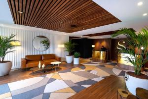 a lobby with a couch and a table and plants at Servotel Saint-Vincent in Nice