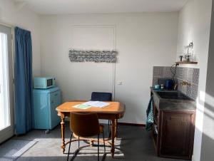 a small kitchen with a wooden table and a sink at HEUVELHOF in Baarsdorp