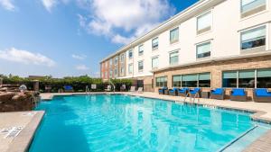 a swimming pool in front of a building at Holiday Inn Express Hotel and Suites Conroe by IHG in Conroe