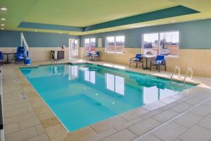 una grande piscina con acqua blu in un edificio di Holiday Inn Express & Suites - Kansas City - Lee's Summit, an IHG Hotel a Lee's Summit