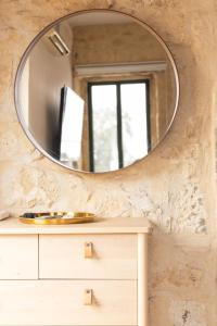 baño con espejo redondo en una pared de piedra en Sapir Boutique Apartments, en Beer Sheva