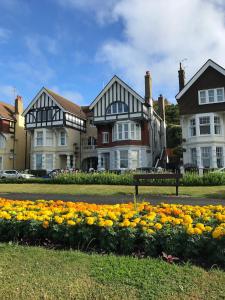 a group of houses with flowers in the grass at Elegant Spacious Seaside Apartment in St. Leonards
