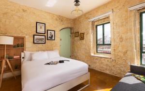 a bedroom with a large white bed and windows at Sapir Boutique Apartments in Beer Sheva