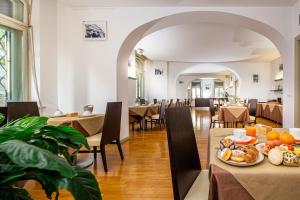 a restaurant with tables and chairs and a plate of food at Europalace Hotel, BW Signature Collection in Monfalcone
