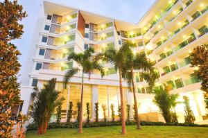 een hotel met palmbomen ervoor bij Vareena palace hotel in Noord Pattaya