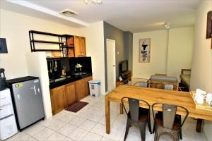 a kitchen and dining room with a wooden table and chairs at Queen Victoria Apartment Batam in Batam Center