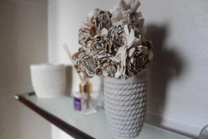 wazon wypełniony kwiatami na stole w obiekcie Fodor Ház w mieście Miercurea-Ciuc