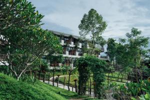ein Gebäude mit Bäumen davor in der Unterkunft Bansaeo Garden and Resort in Chiang Saen