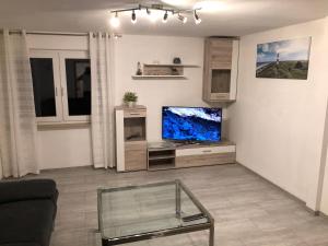 a living room with a tv and a glass table at Ferienwohnung Bömitz in Rubkow