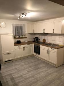 a kitchen with white cabinets and a counter top at Ferienwohnung Bömitz in Rubkow