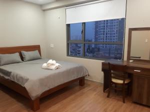 - une chambre avec un lit, un bureau et une fenêtre dans l'établissement Căn hộ 3PN Gold View, 346 Bến Vân Đồn, Phường 1, Q4, HCM, à Hô-Chi-Minh-Ville