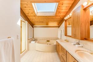 uma casa de banho com uma banheira, um lavatório e uma clarabóia em Crown of the Coast em Crescent City