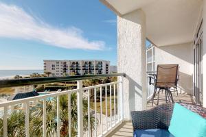a balcony with a chair and a view of the ocean at Seaside Retreat in Litchfield Beach