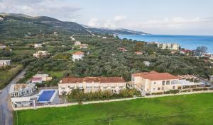 an aerial view of a house on a hill next to the ocean at Aphrodite Studios & Suites - 140m from the beach, by ZanteWize in Alykes +24 photos