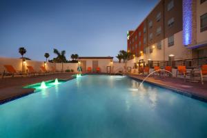 ein Pool vor einem Hotel in der Nacht in der Unterkunft Holiday Inn Express & Suites - McAllen - Medical Center Area, an IHG Hotel in McAllen