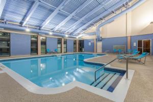 a large swimming pool in a building with blue walls at Holiday Inn Express & Suites Mississauga-Toronto Southwest, an IHG Hotel in Mississauga
