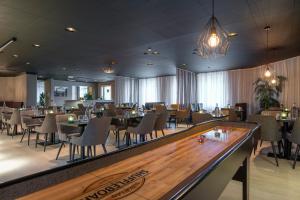 un restaurant avec des tables et des chaises ainsi qu'un bar dans l'établissement Quality Hotel Grand Kristianstad, à Kristianstad