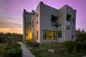 un gran edificio blanco con una puesta de sol en el fondo en Kinmen 2 Home Puju Homestay, en Jinhu