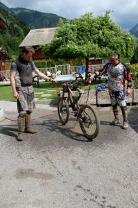 two men standing next to a bike in the street at Résidence Julianna , trajets remontées mécaniques , livraison viennoiseries, piscine couverte in Morzine