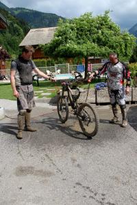 two men standing next to a bike in the street at Julianna , appartements avec services gratuits in Morzine
