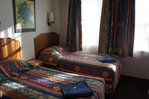 a hotel room with two beds and a window at Moruya Monarch Hotel in Moruya