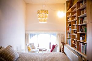 a bedroom with a bed and a book shelf at B&B A Quiet Place in Rossignol