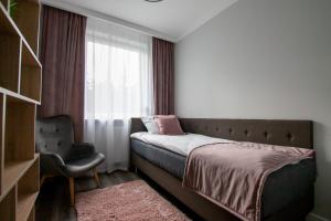 sypialnia z łóżkiem i oknem z krzesłem w obiekcie Apartament Leśny No 4 Blue w Kielcach +22 zdjęcia