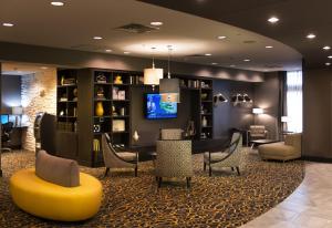 um átrio com uma sala de espera com cadeiras e uma televisão em Holiday Inn Express and Suites Madison Central, an IHG Hotel em Madison