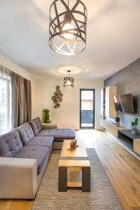 a living room with a couch and a table at Warm Amber Suites Brașov in Braşov