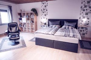 1 dormitorio con 1 cama y 1 silla en Ferienwohnung Leon, en Heinsberg