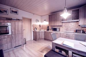 ハインスベルクにあるFerienwohnung Leonの木製キャビネットとテーブル付きの広いキッチンが備わります。