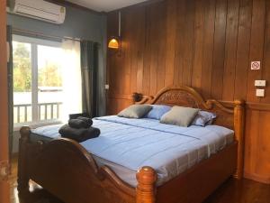 a bedroom with a bed with a teddy bear on it at Ruen Thai Ban Rim Nam in Kamphaeng Phet