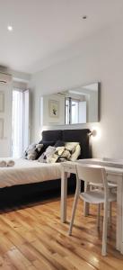 - une chambre avec un lit, une table et un miroir dans l'établissement LEEWAYS LOFT in FUENCARRAL, à Madrid