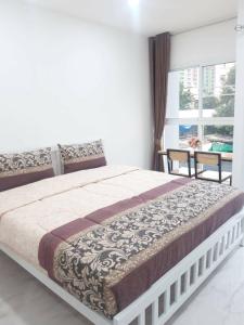 曼谷的住宿－Parvena Ratchada，卧室内的一张大床,设有窗户
