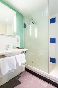 a bathroom with a shower with a glass door at ibis budget Angoulême Nord in Champniers +51 photos