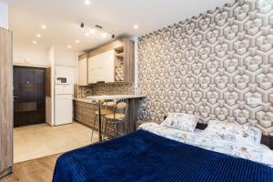 um quarto com uma cama azul e uma cozinha em 2 Kn. Romana Apartment em Lviv