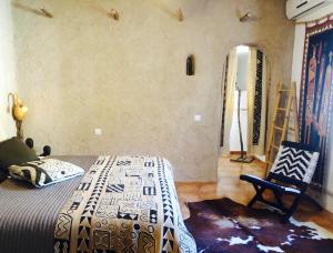 a bedroom with a bed and a chair in a room at Valle de Oro in Villanueva de Algaidas