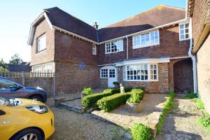 a yellow car parked in front of a brick house at Seagull Cottage, Aldwick in Bognor Regis