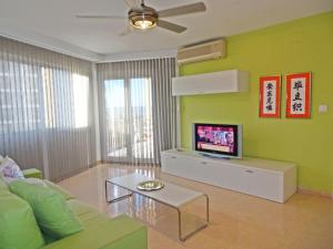 ein Wohnzimmer mit Sofa und Fernseher in der Unterkunft ALMIRANTE Vista al mar - Alquiler familias in Playa de Gandia