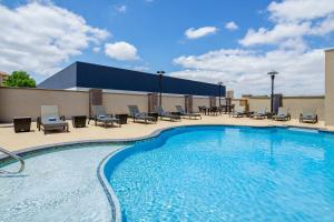 una gran piscina con sillas y mesas en Holiday Inn Express & Suites Lubbock Central - Univ Area, an IHG Hotel, en Lubbock