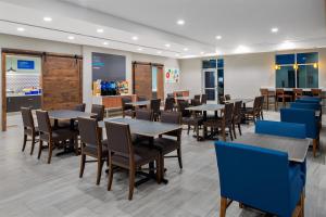 Holiday Inn Express & Suites Lubbock Central - Univ Area, an IHG Hotel في لوبوك: غرفة طعام مع طاولات وكراسي