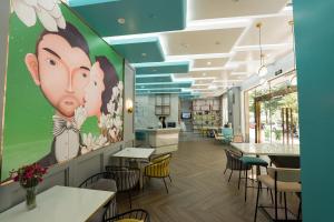 清遠市にあるMagnotel Renmin Road City Hall QingYuanの猿の絵を描いたテーブルと椅子のレストランを併設