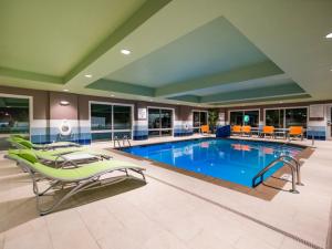 una piscina en una habitación de hotel con sillas en Holiday Inn Express & Suites - Southaven Central - Memphis, an IHG Hotel, en Southaven