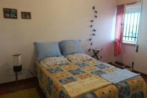 a bedroom with a bed with blue pillows at Refúgio do Douro Guest House in Bemposta