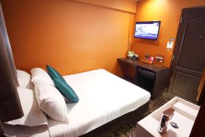 um quarto de hotel com uma cama e uma televisão de ecrã plano em Violet Tower at Khaosan Palace em Bangkok