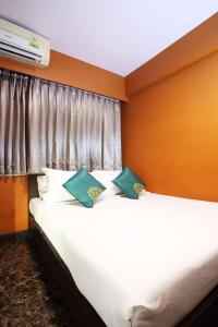 2 bedden in een kamer met witte en groene kussens bij Violet Tower at Khaosan Palace in Bangkok