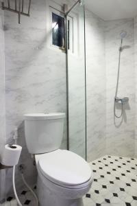 een badkamer met een toilet en een glazen douche bij Violet Tower at Khaosan Palace in Bangkok