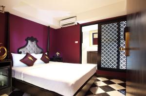 een slaapkamer met een wit bed en paarse muren bij Violet Tower at Khaosan Palace in Bangkok