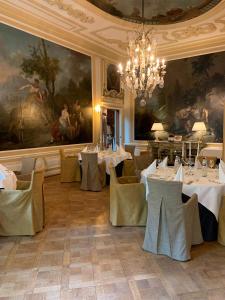 une salle à manger avec des tables et des chaises ainsi qu'un lustre dans l'établissement Landgoed Duin & Kruidberg, à Santpoort-Noord