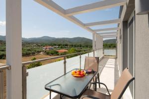 a balcony with a table and bowl of fruit on it at Astra Sarti Luxury Suites in Sarti